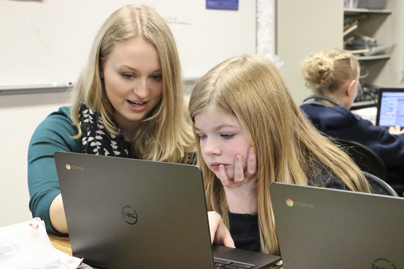 CAM Academy teacher Alexis Scott assists student Emersyn Christenson on a computer at the school. Photo courtesy of Battle Ground Public Schools