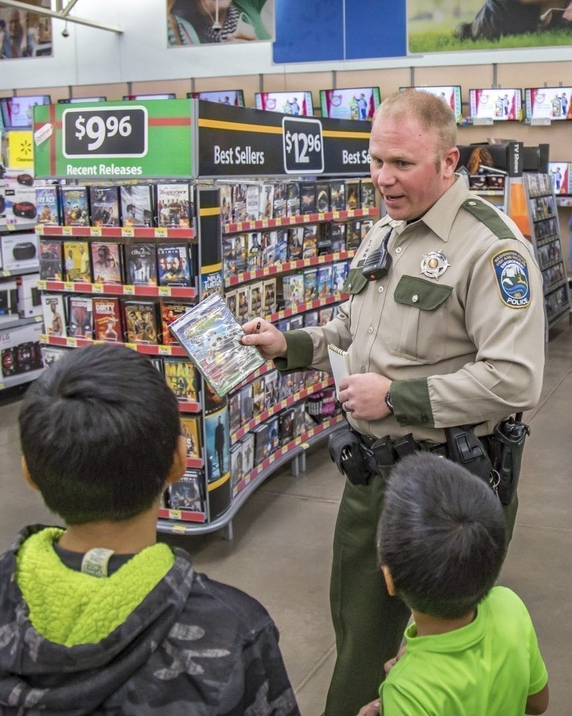 Brandon Chamberlain, of the Washington Department of Fish and Wildlife, helps a pair of kids with their shopping Saturday at the Woodland Walmart. Photo by Mike Schultz