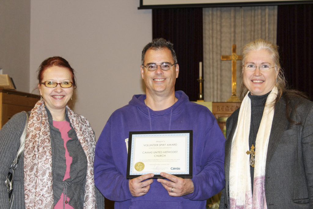 Rev. Richenda Fairhurst (right) says she’s honored that her church, the Camas United Methodist Church, recently received the Camas Mayor’s Volunteer Spirit Award for its sponsorship of the city’s Movies in the Park event for the past 10 years. Here, Fairhurst is pictured with congregants Byron Boyd (center, holding volunteer spirit award) and Dr. Tatiana Kolchanova (left) in the church’s sanctuary. Photo by Kelly Moyer