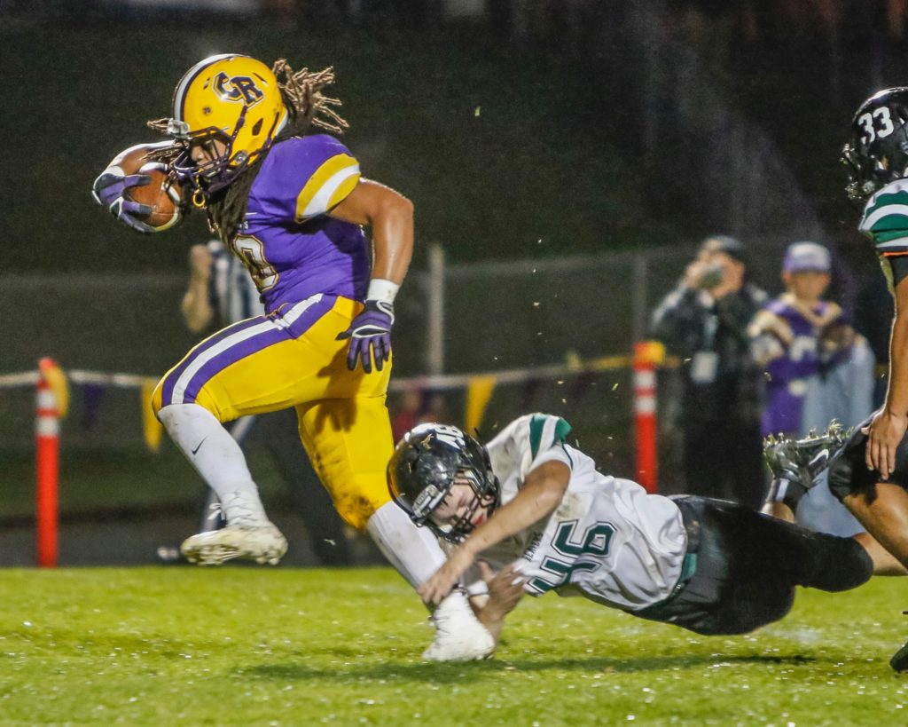 Columbia River running back Hunter Pearson (30) out steps the grasp of a Woodland defender Jack Wear (46) and races for a touchdown Friday against the Beavers. Photo by Mike Schultz.