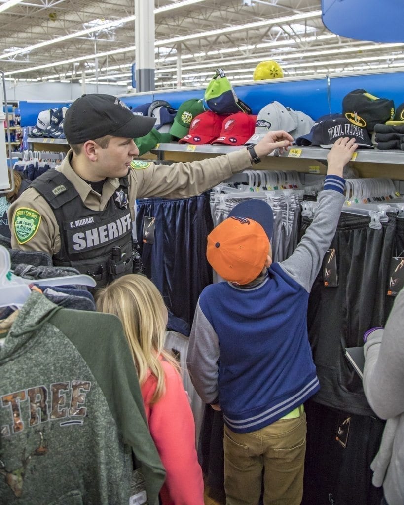 Sometimes it’s nice to have someone around who can reach the top shelf, Craig Murray of the Clark County Sheriff’s Office helps a youngster do just that Saturday at the Shop With a Cop event at the Woodland Walmart. Photo by Mike Schultz