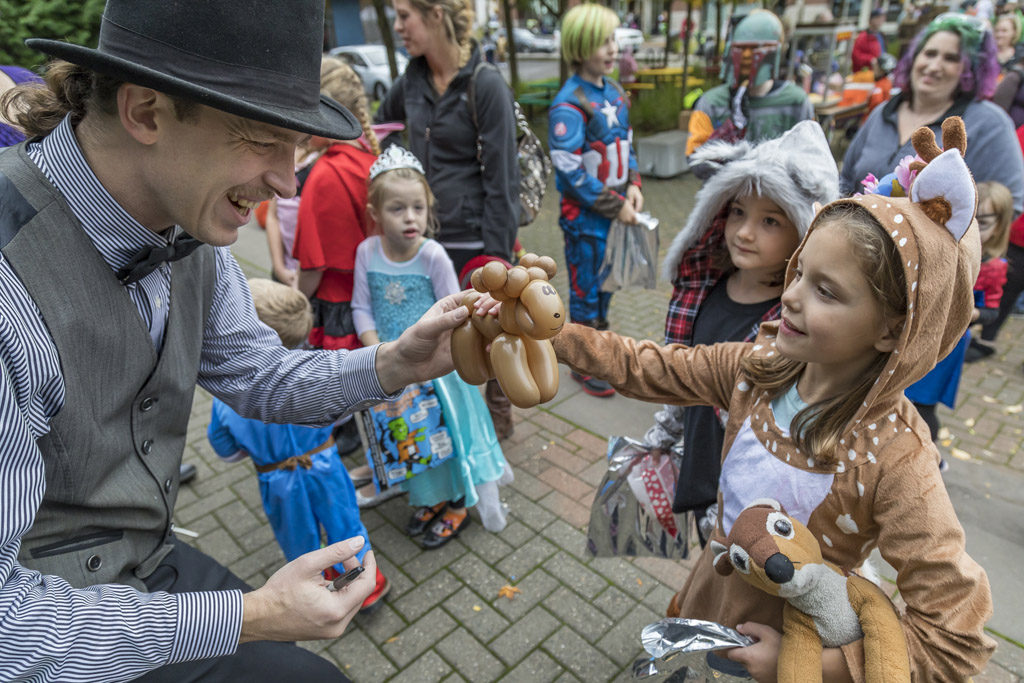 Balloonist Dominic Hunter was on hand Wednesday at the annual Downtown Washougal Pumpkin Harvest Festival. Here, Hunter offers one of his creations to 7-year-old Aubrey Gay of Washougal. Photo by Mike Schultz