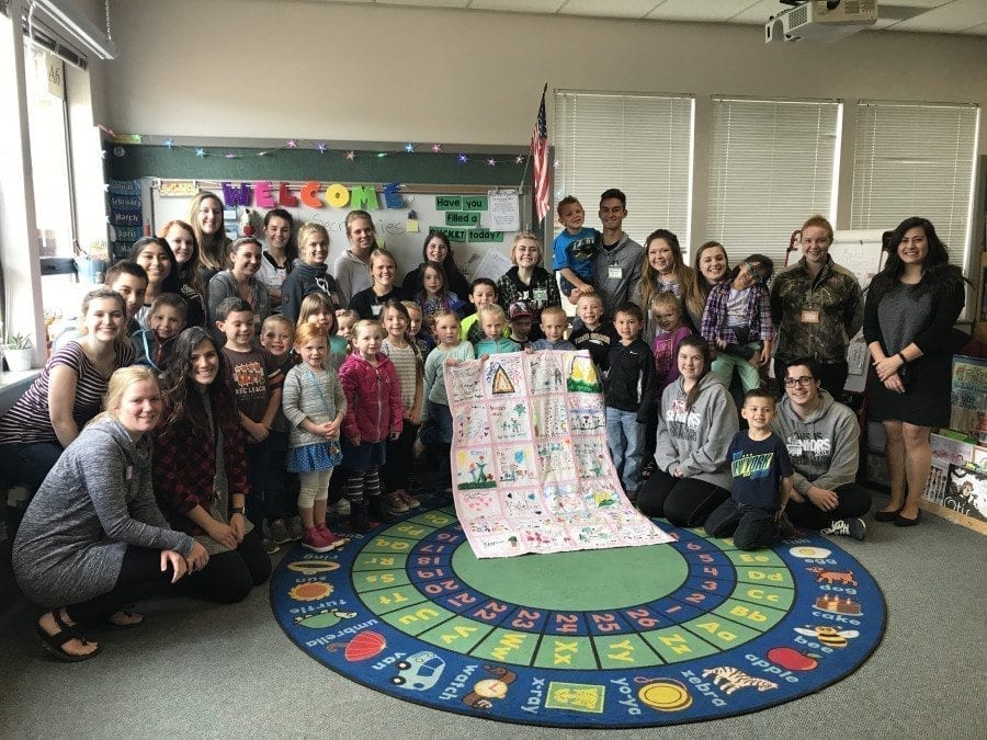 Students in the Older-Younger kindergarten program in the Battle Ground School District pose with a special quilt they created. Photo courtesy of Battle Ground School District