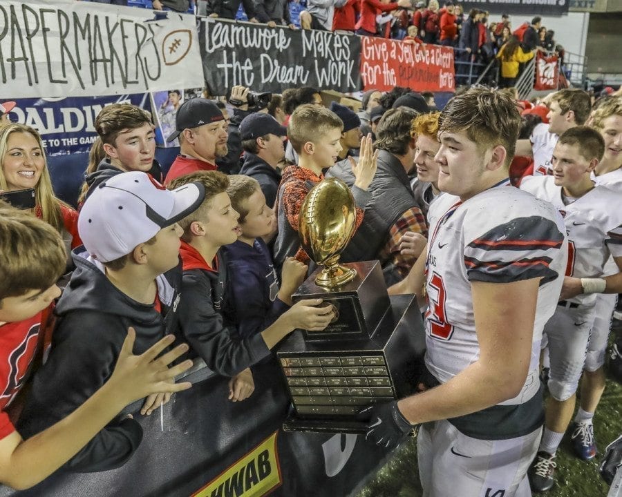 Camas football player Marshall McIvor shares the state championship trophy with some of the team’s fans after the Papermakers won the 4A title. Photo by Mike Schultz