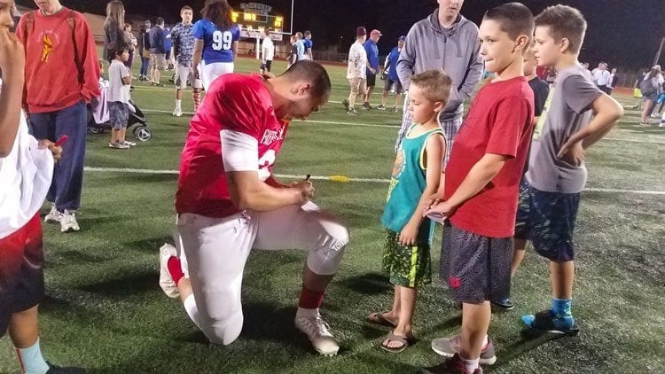 Jordan Hickman of Hudson’s Bay signs autographs after leading the West All-Stars to a 38-23 victory at Saturday’s Freedom Bowl Classic. Photo by Paul Valencia