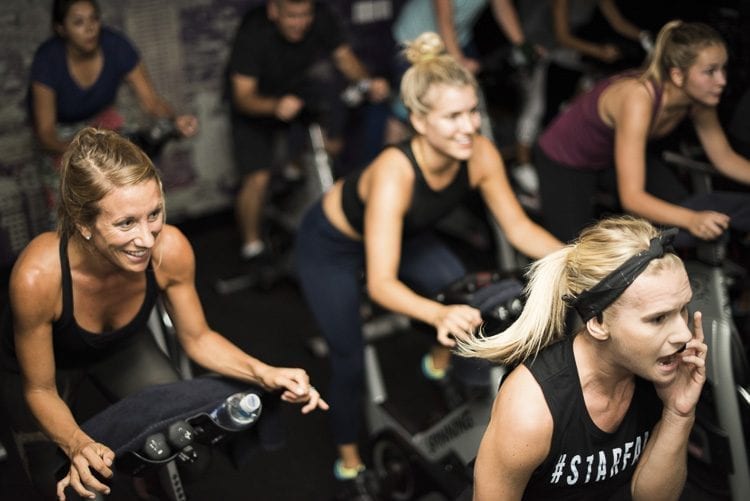 Each StarCycle class is led by an instructor and lasts 45 minutes, giving participants a full-body workout on stationary bicycles. Photo courtesy of StarCycle