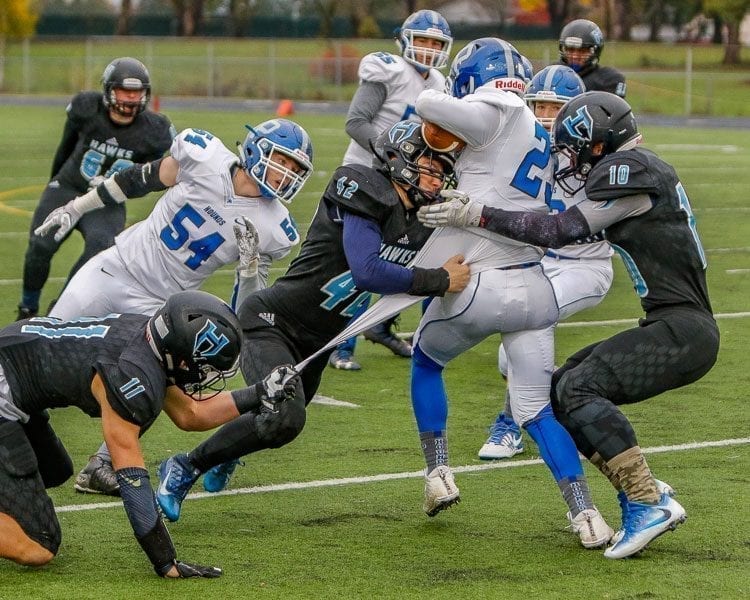 Hockinson’s defense will have its toughest test of the season trying to stop Tumwater’s disciplined, run-oriented offense in Saturday’s Class 2A state championship game at the Tacoma Dome. Here, Hockinson defenders Sawyer Racanelli (11), Jonathon Domingos (42) and Kyle Brabec (10) stop a Pullman ball carrier in a previous playoff game. Photo by Mike Schultz