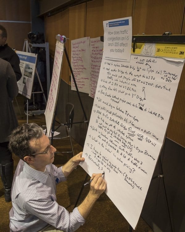 At the ODOT open house regarding tolls or value pricing, attendees could engage in dialogue by writing their concerns and experiences on easels provided for the public. Here, Value Pricing Senior Planner Mike Mason adds information to an informational easel. Photo by Mike Schultz
