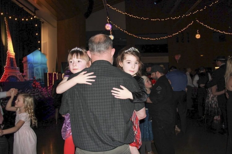 This father had his arms full Saturday at the 14th annual Woodland Father/Daughter Ball hosted by Grace Community Church at Woodland High School. Photo courtesy of Grace Community Church