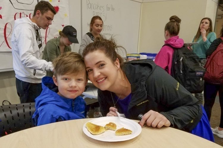 Brittany Goff, the adviser for the (Miss)ter Union Pageant, poses with her son Henry as they took advantage of the pancakes made by contestant Kaitlyn Milliken. The months-long event raises funds for charity. The pageant itself is Saturday at Union High School. Photo by Paul Valencia
