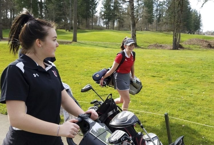 Union golfer Katie Brockley (left) and Prairie’s Delainey Patterson are happy to be starting another season of girls golf. Monday featured a lot of wind, but it was a mostly sunny day. Photo by Paul Valencia