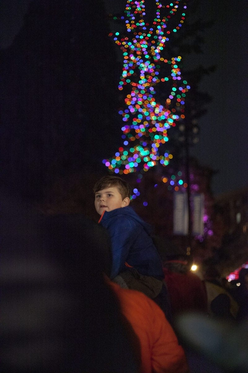Griffin Stixrud sits atop his mother Casie’s shoulders to watch the tree light up at the Vancouver tree lighting. The event was hosted by area businesses and churches, in the square of Esther Short Park. Photo by Jacob Granneman