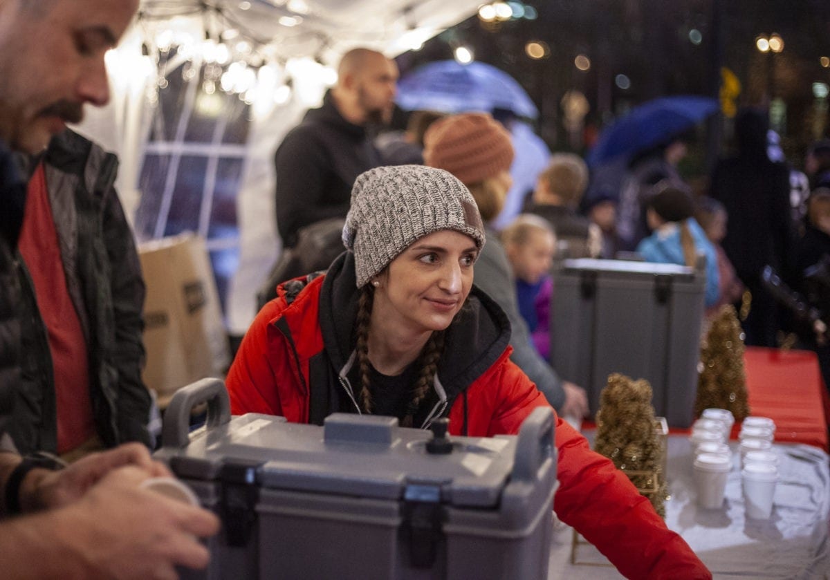 Darci Andrews from City Harvest Church, serves people hot apple cider during one of the many rainy deluges at the Vancouver tree lighting on Black Friday. Photo by Jacob Granneman