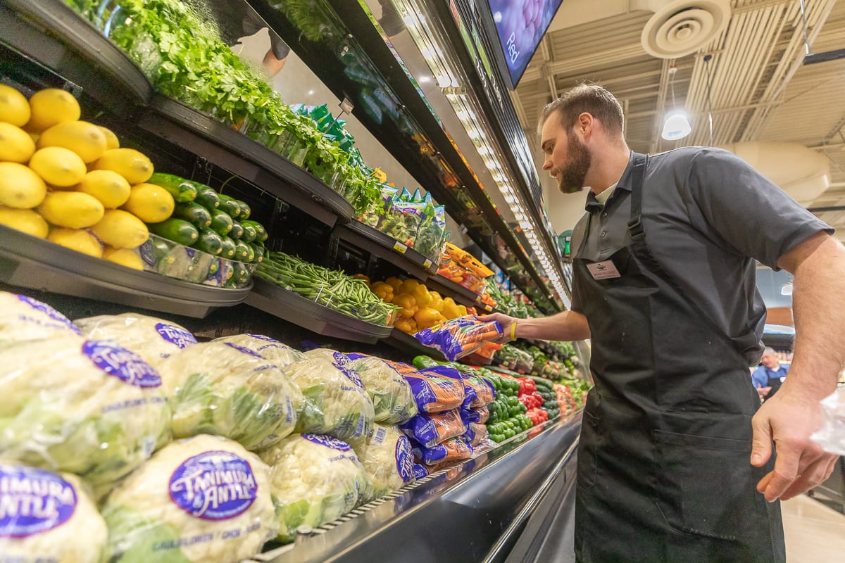 Rosauers Supermarket Produce Manager Bryan Fallquist puts the final touches on his display ahead of the Ridgefield location grand opening on Saturday. Photo by Mike Schultz