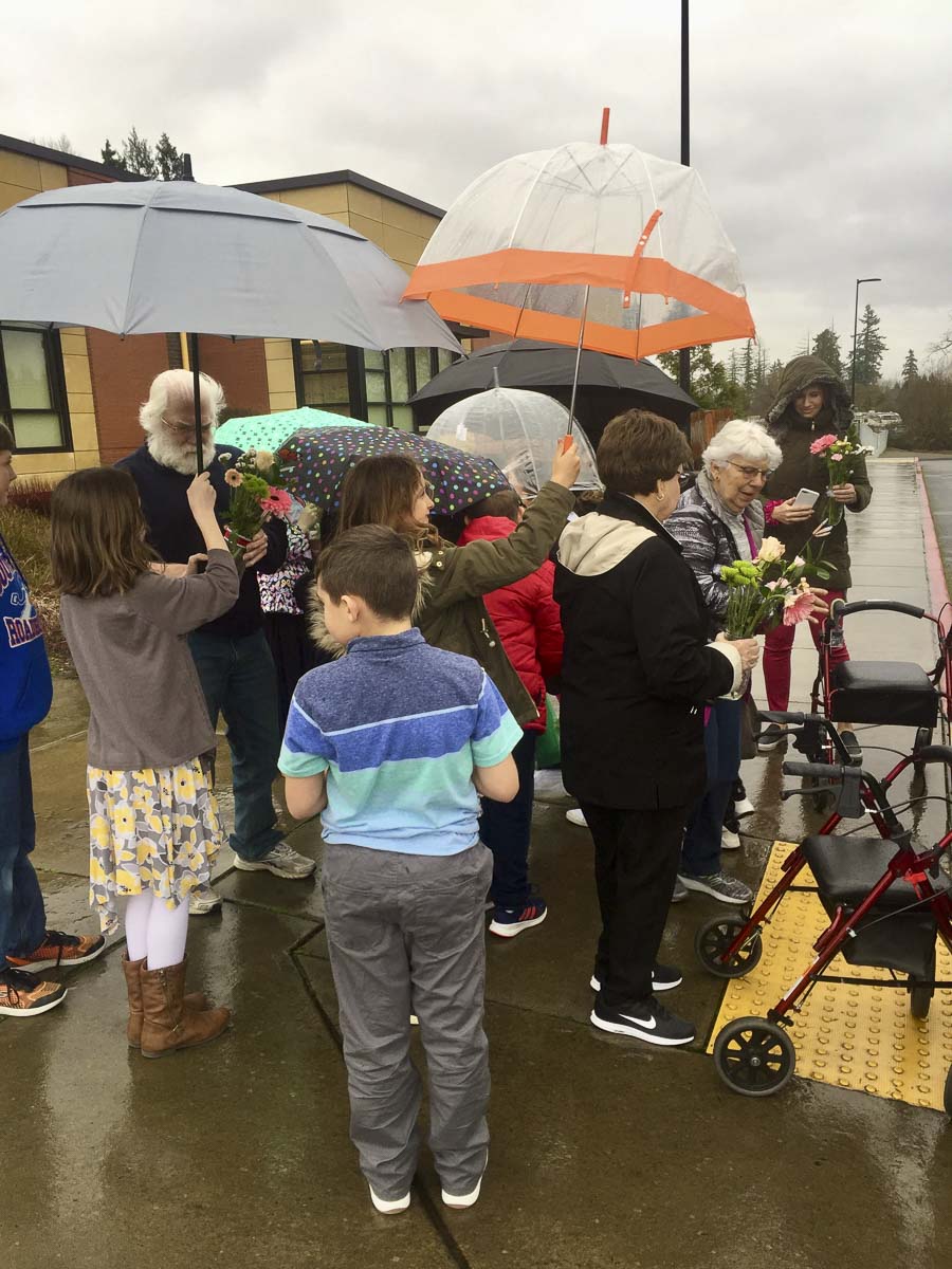 After a classroom visit, South Ridge Elementary students shield their friends from the rain as they wait to board buses to return to Highgate. Photo courtesy of Ridgefield Public Schools