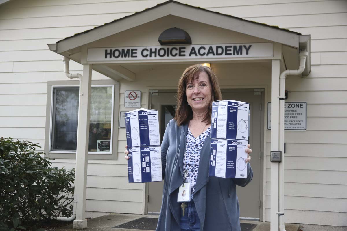 Janet Locasio, Program Coordinator, Home Choice Academy, holds boxes of masks to be donated to Clark County hospitals. Photo courtesy Evergreen Public Schools