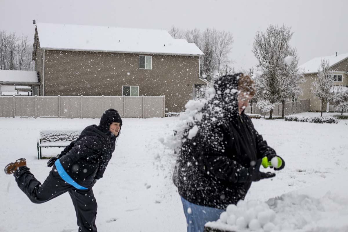 Wyatt Sanders of Battle Ground pelts his dad, Tarl, with a snowball on Saturday morning. Photo by Chris Brown