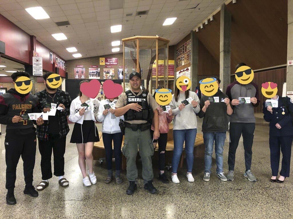 Students at Prairie High School stand with their school resource officer, Deputy Childers, back in November. Each received a gift card for driving safely. Photo courtesy of Target Zero