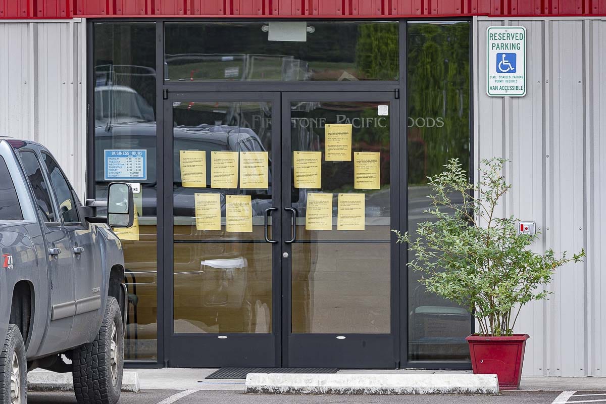 Notices posted by Clark County Public Health about a COVID-19 outbreak are taped to the main entry at Firestone Pacific Foods in Vancouver. Photo by Mike Schultz
