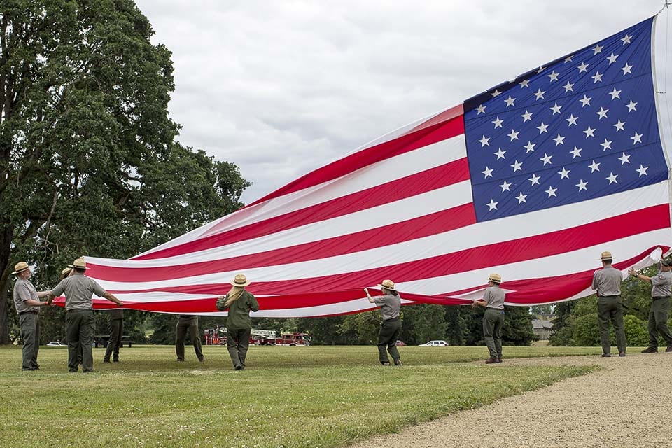 National park rangers raise the large garrison flag on the Vancouver Barracks Parade Ground on Flag Day, 2018. Photo courtesy of National Park Service/Junelle Lawry