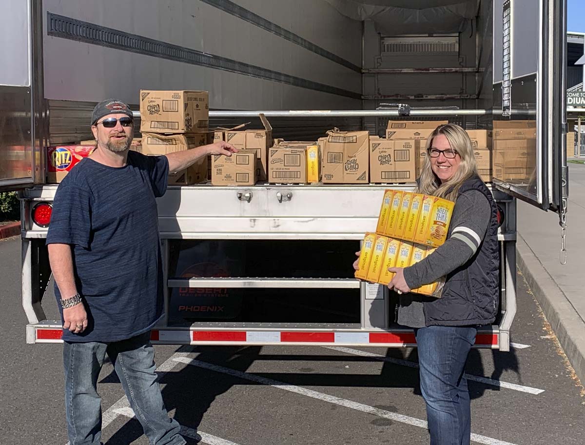 Shawn Fenmore, a driver with Landstar Ranger Trucking, drove 25 cases of unwanted cookies and crackers up to Woodland after his last stop in Vancouver to say thanks for Woodland Public Schools opening the high school as a temporary rest area for drivers. Photo courtesy of Woodland Public Schools