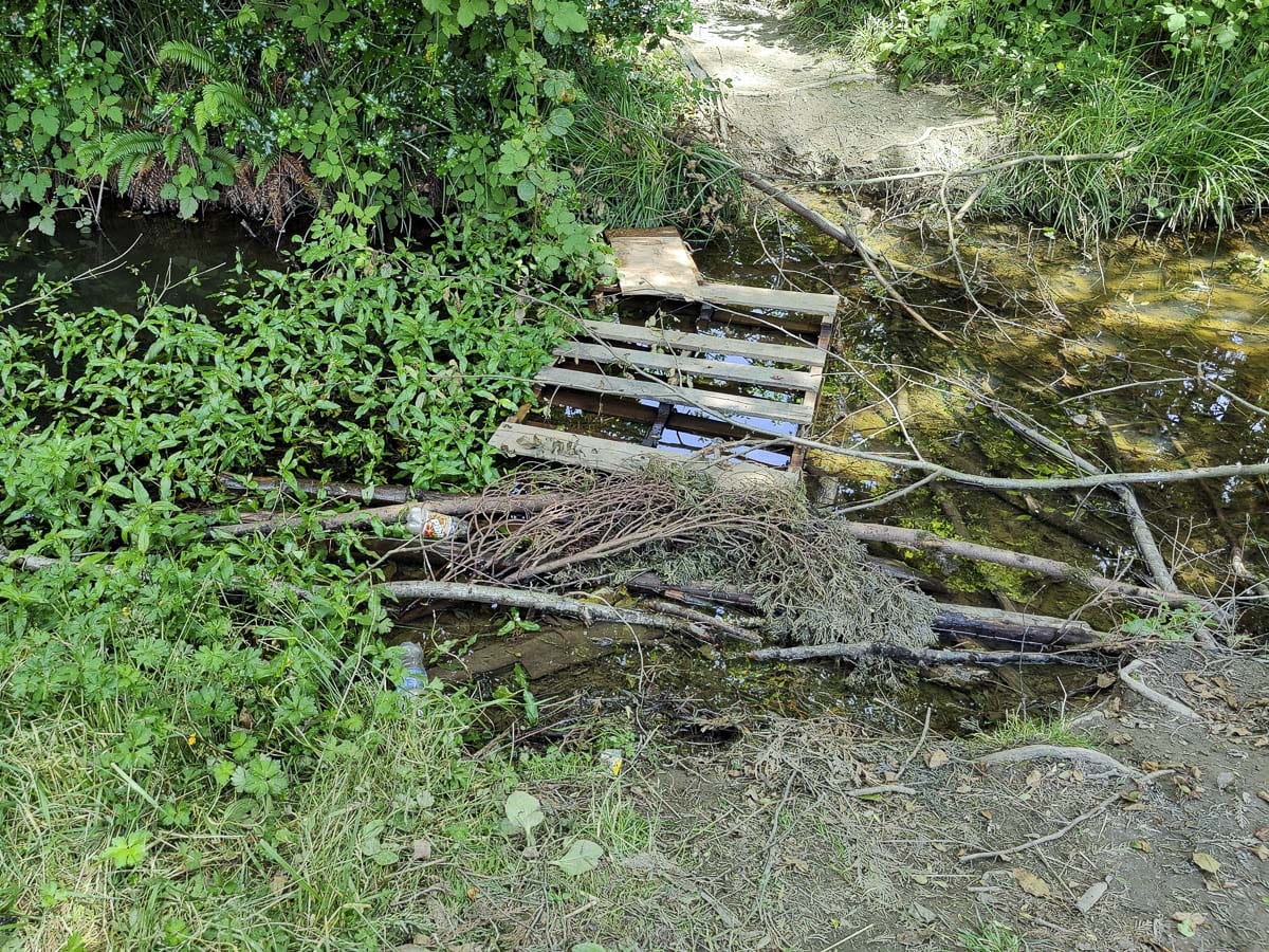 Pallets and other wood have been used to cross a seasonal creek in Cedar Trails Park in Battle Ground. Photo by Chris Brown