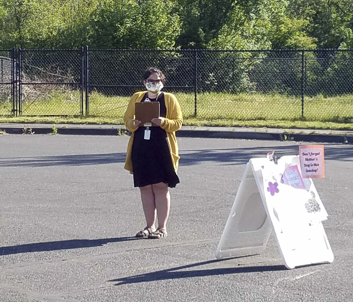 Nearly two dozen district employees helped make the plant sale happen like Stacy Gould pictured here wearing a mask while she checked in customers. Photo courtesy of Woodland Public Schools