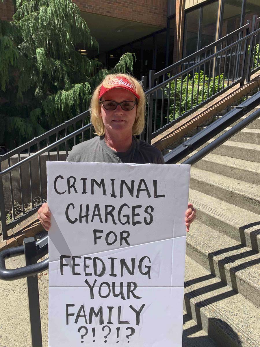 Kelly Carroll poses with a handmade sign outside the Clark County Courthouse in this undated photo from her business’ Facebook page. Photo courtesy Kelly Carroll/The PetBiz