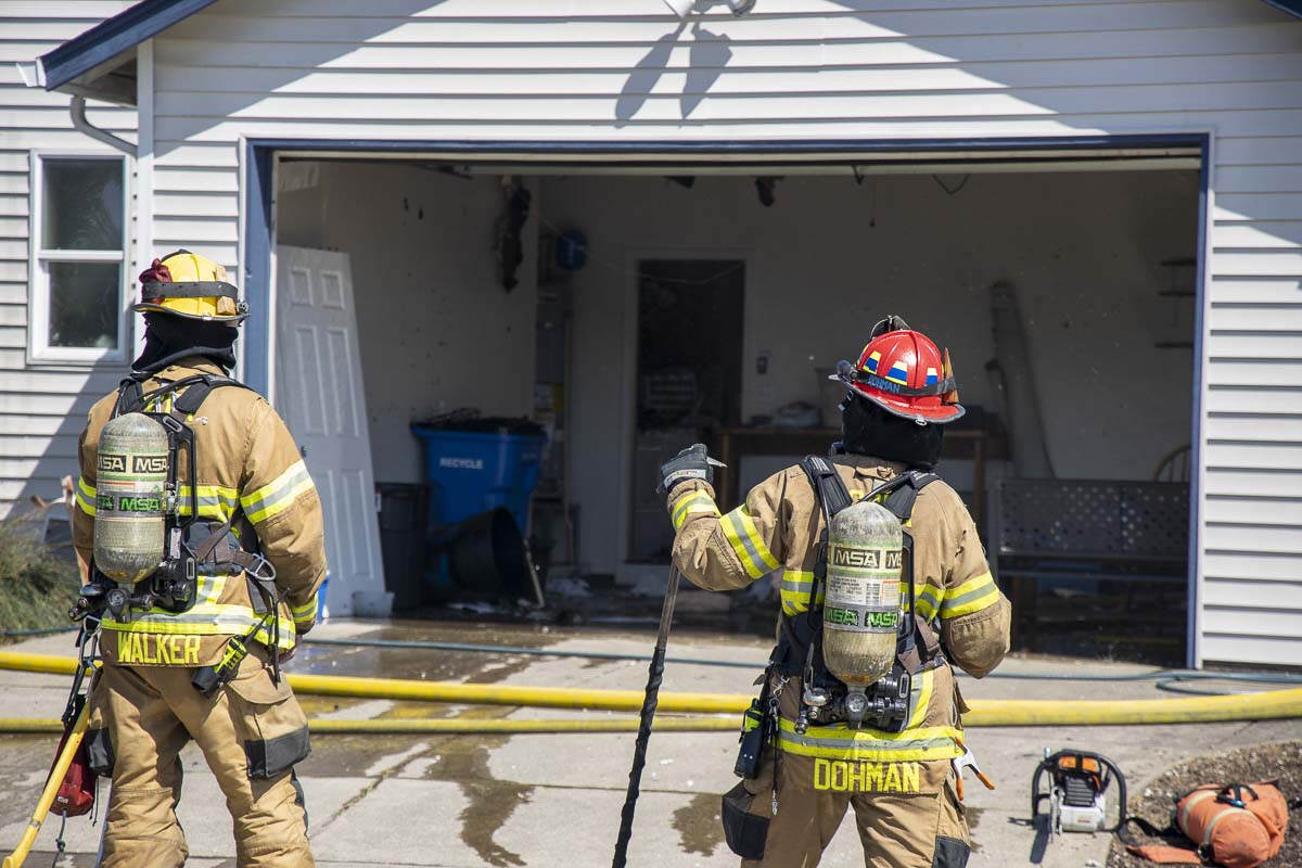 Firefighters with Clark County Fire District 3 wait to go back into a burning home in Battle Ground on Monday. Photo by Chris Brown