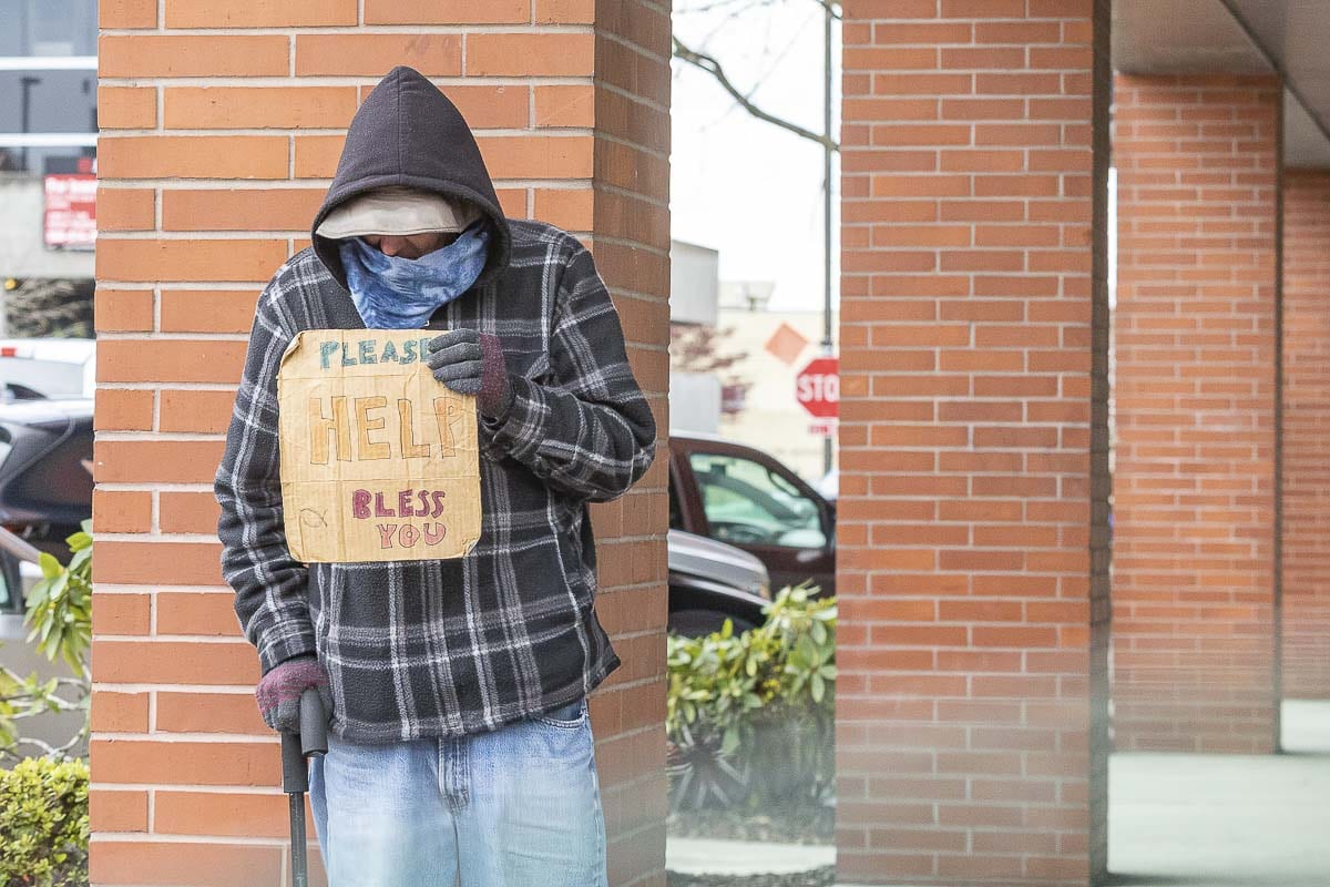 A homeless man holds a sign in Vancouver last March. Photo by Mike Schultz
