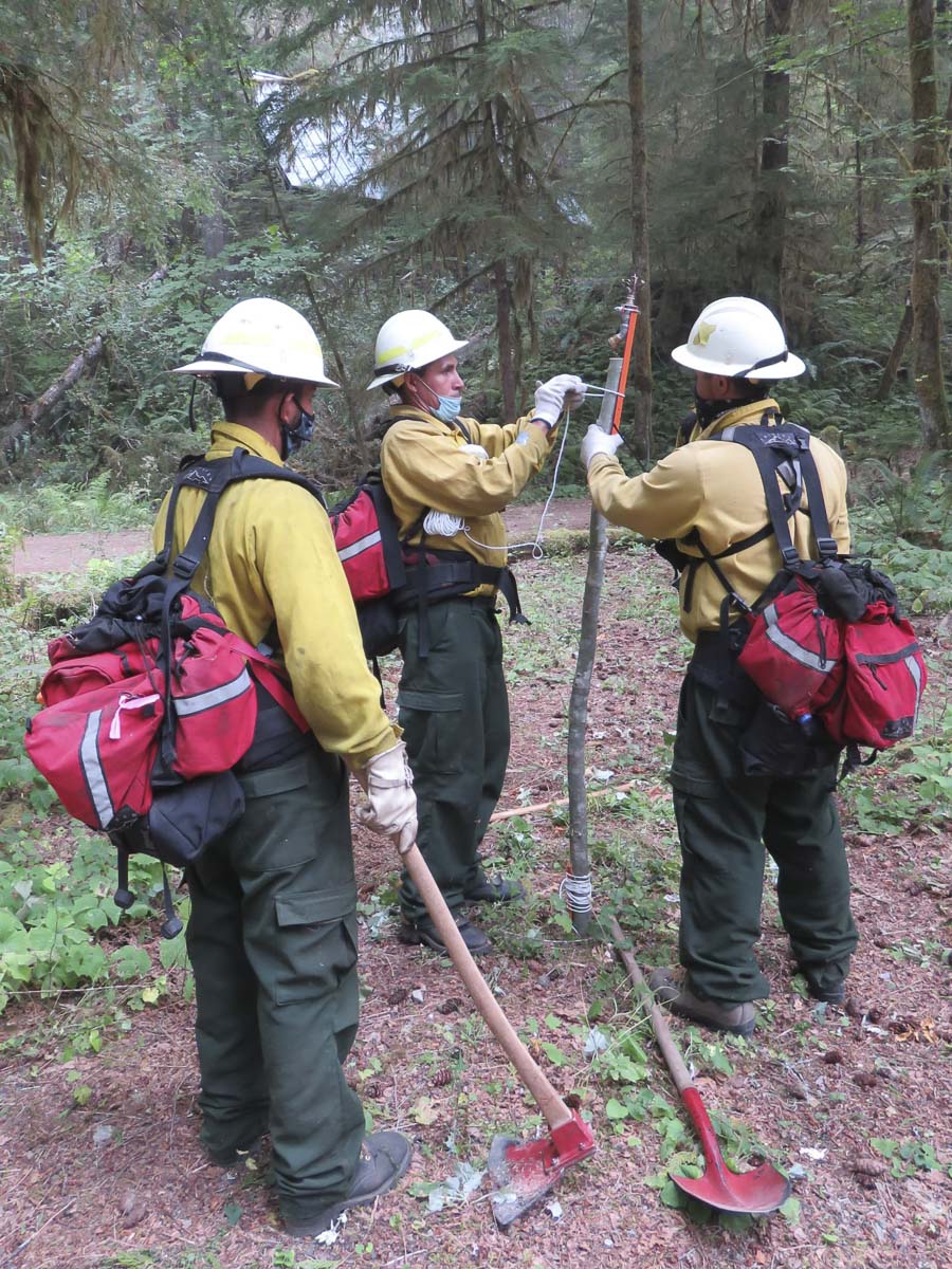 Fire crews with the Northwest Incident Management Team 12 work to install sprinklers to protect buildings at Government Mineral Springs. Photo courtesy U.S. Forest Service