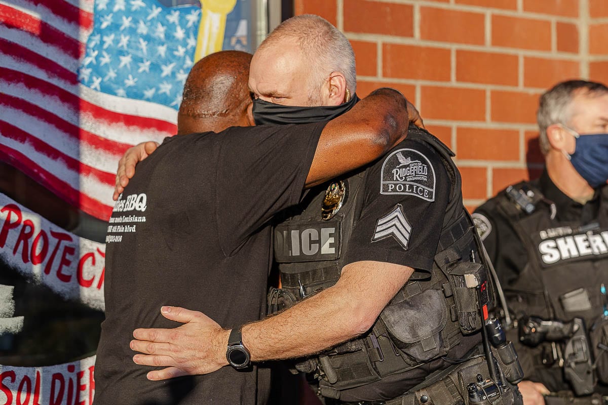 Jeff Pettit of the Ridgefield Police Department gives Charles Bibens, owner of Goldies BBQ, a hug as Bibens was surprised by a gift from Kindness 911 and law enforcement officials. Photo by Mike Schultz
