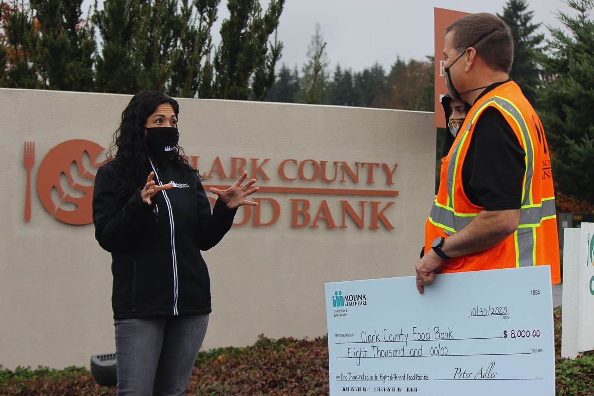Aideet Pineda (left) Community Engagement Specialist at Molina Healthcare of Washington, presents Clark County Food Bank with a $8,000 donation from Molina to support their work in feeding the community. Photo courtesy of Molina Healthcare