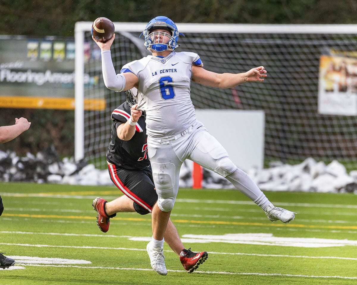 La Center quarterback Tom Lambert had to scramble before throwing this pass Saturday. No matter how he did it, it worked. He threw for a school-record seven touchdown passes in a win over Fort Vancouver. Photo by Mike Schultz