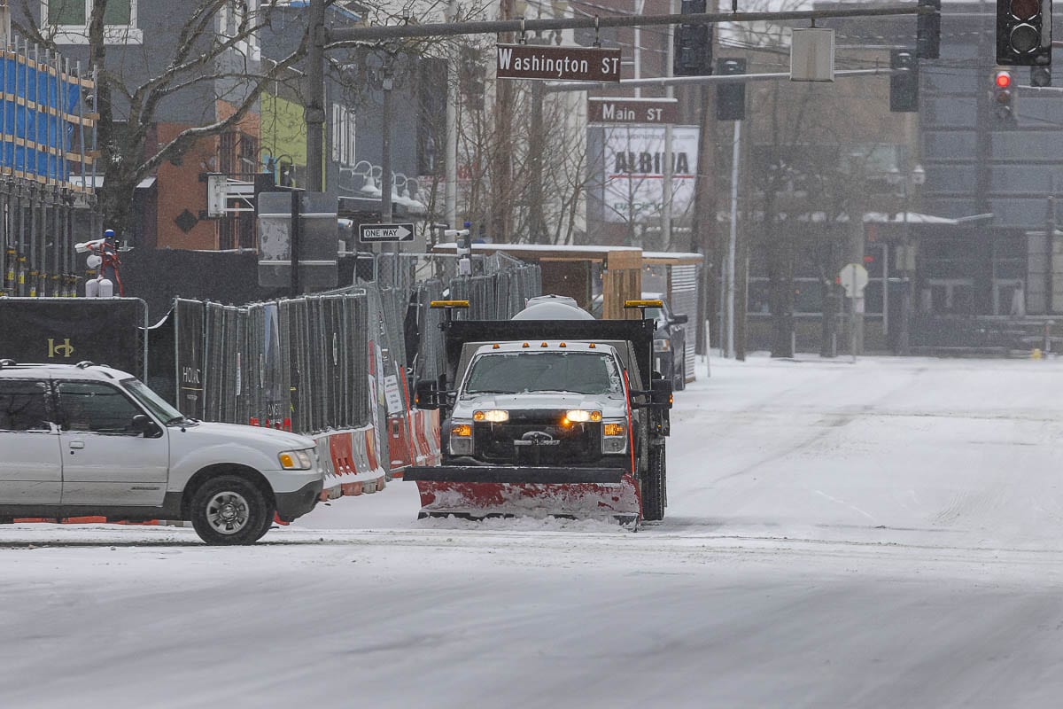 A Vancouver Public Works snow plow clears a snow-covered road downtown on Friday. Photo by Mike Schultz