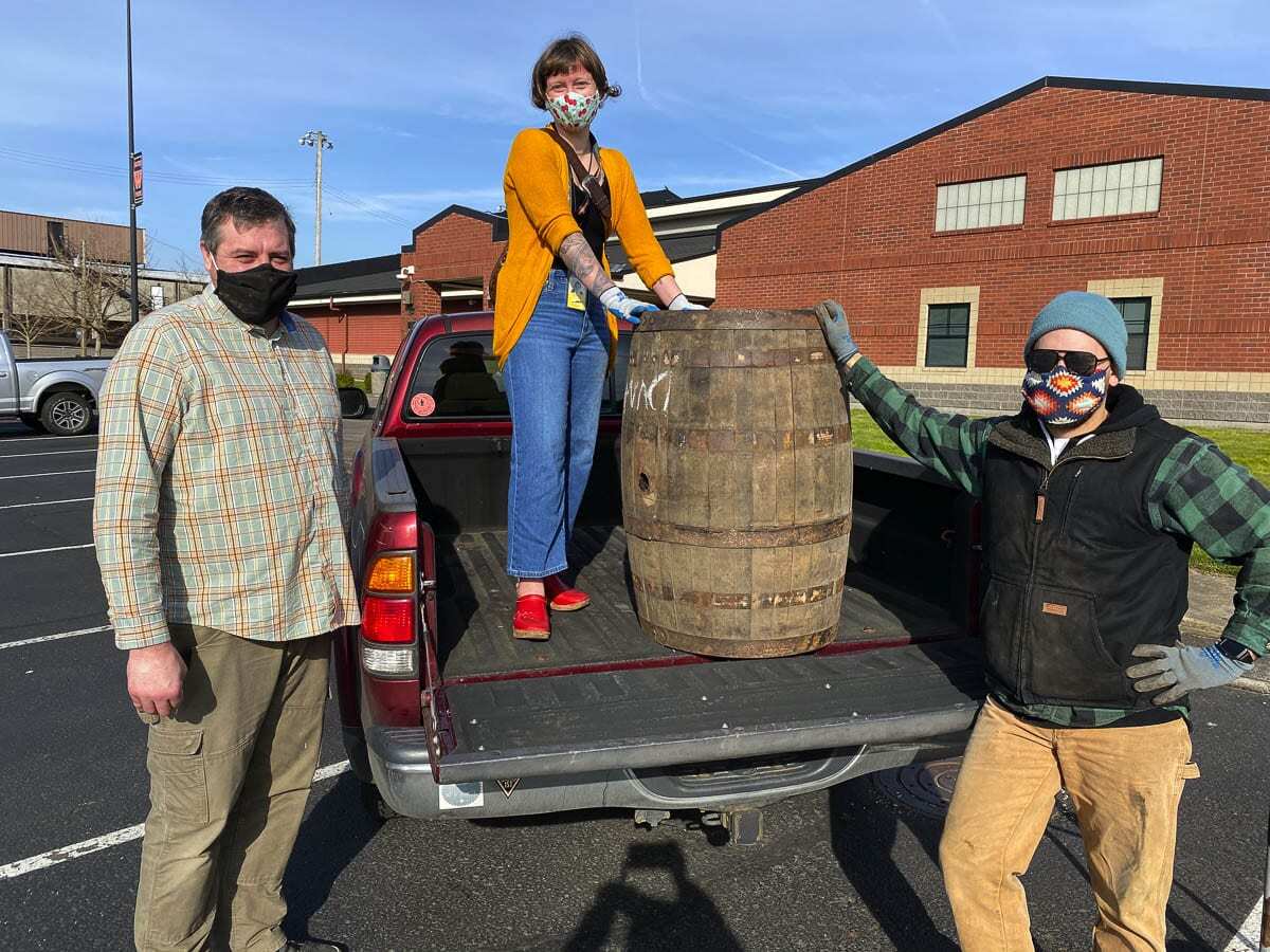 Brent Mansell, Washougal High School CTE Woods Technology teacher, and Alexandra Yost, CTE Pro Tech for the Washougal School District, and Derek Rivilo, from Logsdon Farmhouse Ales, gather to unload the four wooden barrels donated to the Washougal School District. Photo courtesy of Washougal School District
