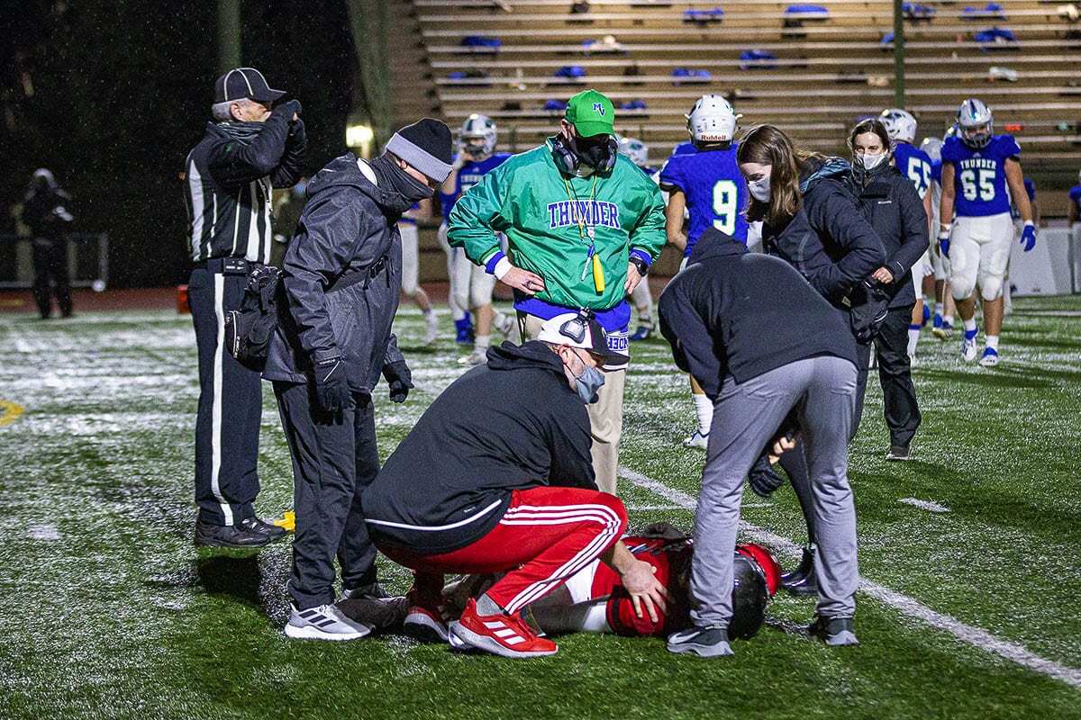 Liam Mallory of Union, surrounded by trainers and coaches from both teams Friday, suffered a knee injury. “The game’s the game. What can you do? But I still enjoyed every single moment of it,” Mallory said. Photo by Mike Schultz
