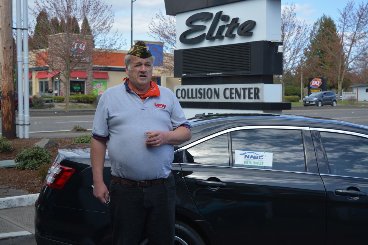 Scott Bingham stands by a 2015 Ford Taurus given to him at Elite Collision Center in Battle Ground Friday. This car was donated to Elite free of charge from the National Auto Body Congress Recycled Rides program and the Veterans of Foreign Wars organization. Photo by Dan Trujillo