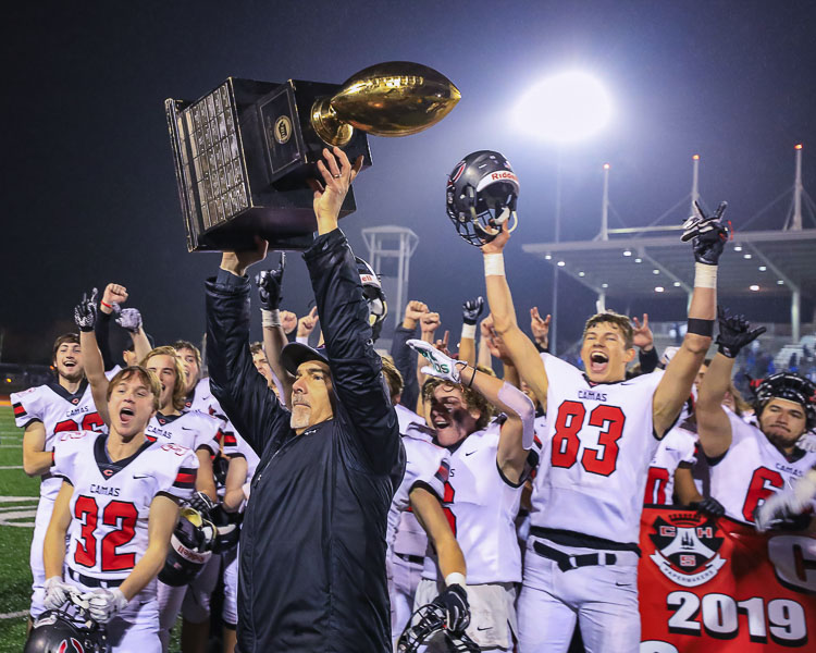 Camas coach Jon Eagle holds up the state championship trophy in December 2019. This was the second state title for Camas. Eagle resigned as the head coach and is going to be an assistant coach at Portland State University. Photo by Mike Schultz