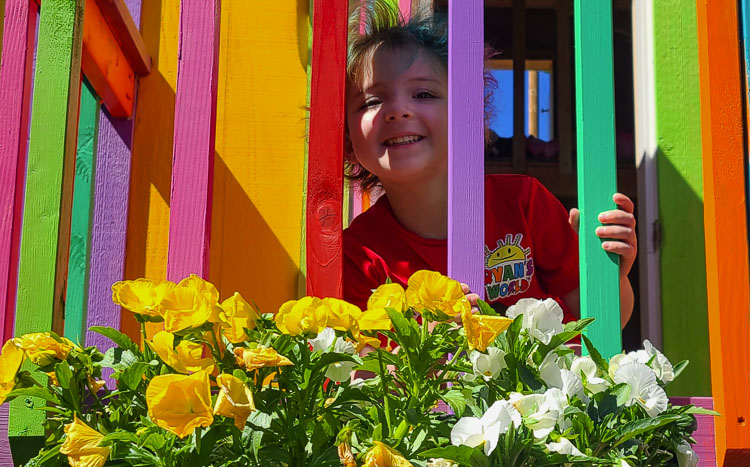 Olivia Sexton loves taking care of her flowers outside of her playhouse. It was her wish to have a play structure in her backyard. Make-A-Wish made it a reality. Photo by Paul Valencia