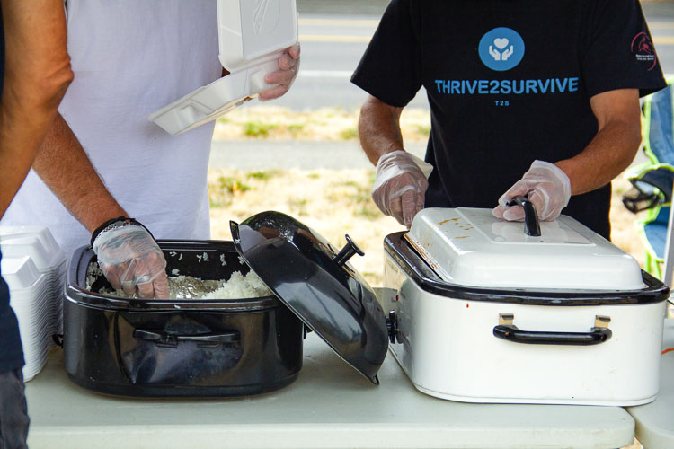 A volunteer, wearing a Thrive 2 Survive shirt, gets ready to serve a meal to those in need Sunday at the Thrive 2 Survive event at River City Church in Vancouver. Photo courtesy Clarissa Sidhom