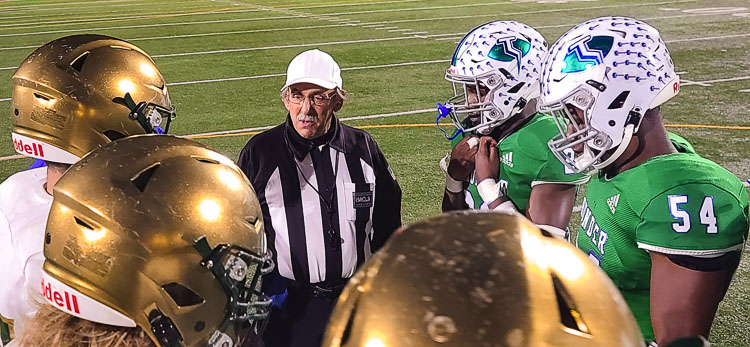 Rick Gilbert gives instructions to players from Mountain View and Evergreen prior to the coin flip Thursday night at McKenzie Stadium. Photo by Paul Valencia