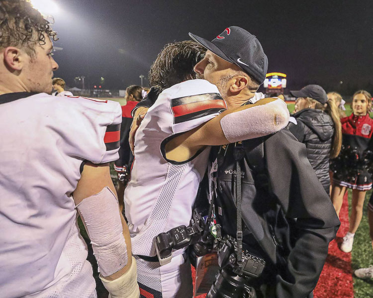 Kris Cavin got a hug from a Camas football player after the team won the 2019 state championship. Cavin has captured special moments of his own with his camera for years. Photo by Mike Schultz