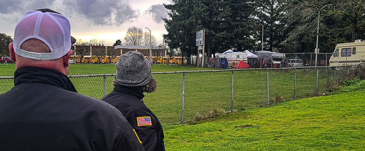 Resource officers for Vancouver Public Schools keep an eye out during spring sports practices at Fort Vancouver High School. Homeless camps have been set up just outside campus property. Photo by Paul Valencia