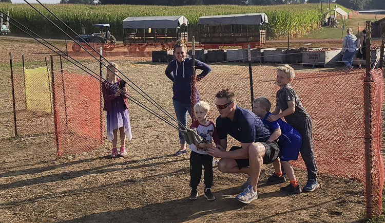 The Parker family from Camas - Kenneth and Kelsy, with children Kaileigh, Kenneth Jr., Knox, and Kieran team up to find the perfect launch angle for their pumpkin. Photo by Paul Valencia