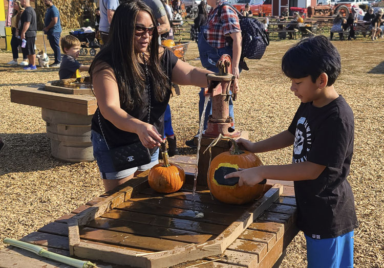 Janet and Kaihe Dunaho clean off their pumpkins that they found at Bi-Zi Farms. Photo by Paul Valencia
