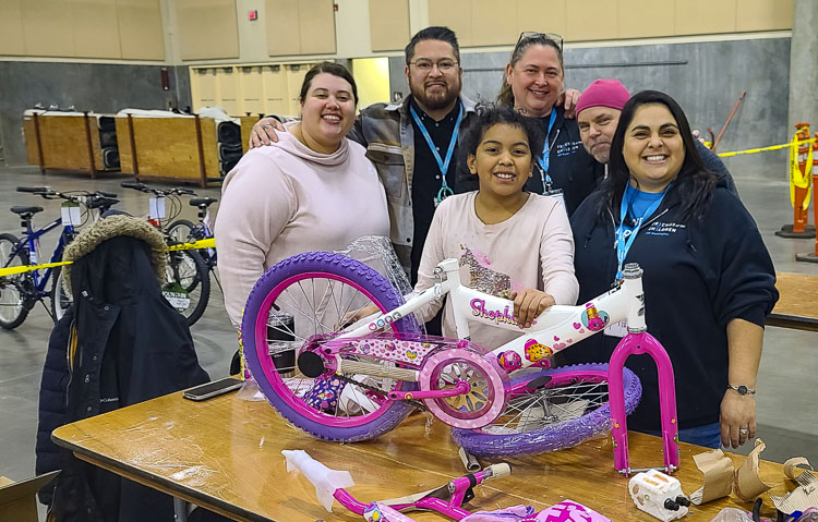 Representatives of Friends of the Children, Southwest Washington chapter, helped build bicycles on Saturday. Friends of the Children will help deliver the bicycles to children in need. Photo by Paul Valencia