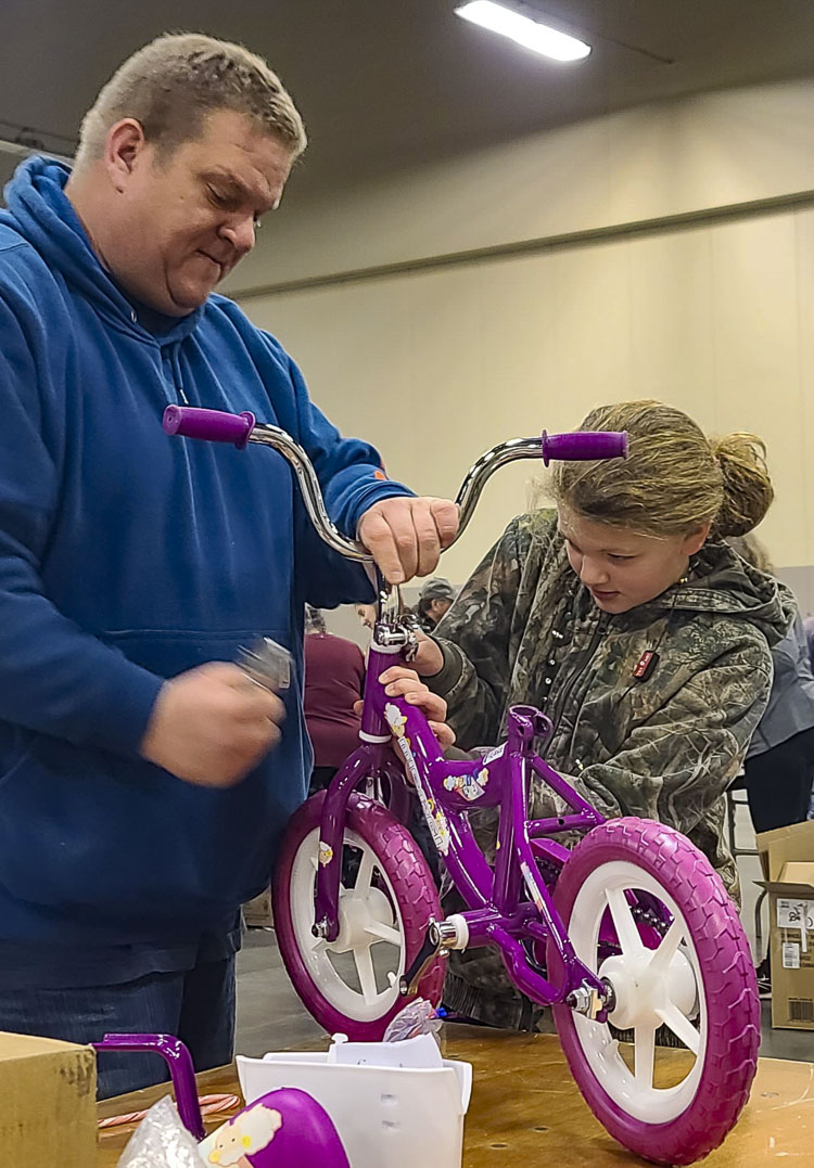 Kyle Buttolph and his daughter Lindsey, from Ridgefield, were among the first in line to start building bicycles at the Bike Build at the Clark County Fairgrounds on Saturday. Photo by Paul Valencia