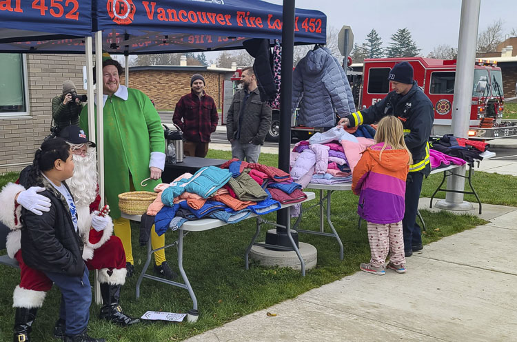 Santa Claus, Buddy the Elf, and Vancouver firefighters helped find coats for children in need at Marshall Elementary School on Tuesday. This is part of Operation Warm mission, to provide coaches for children during the winter months. Photo by Paul Valencia