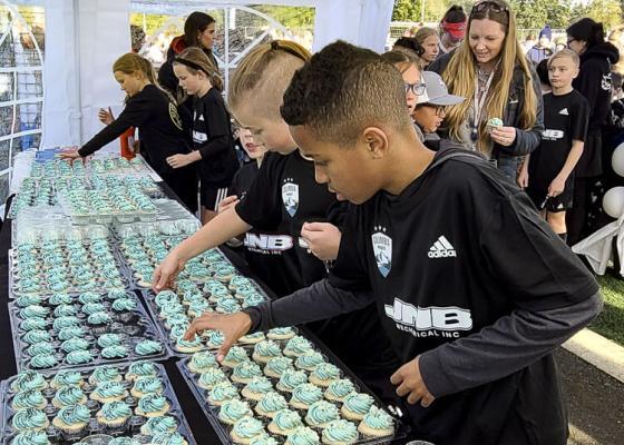 Soccer players grab a cupcake as part of the celebration of the name change for their club. The Washington Timbers brand is now Columbia Premier Soccer Club. Photo by Paul Valencia